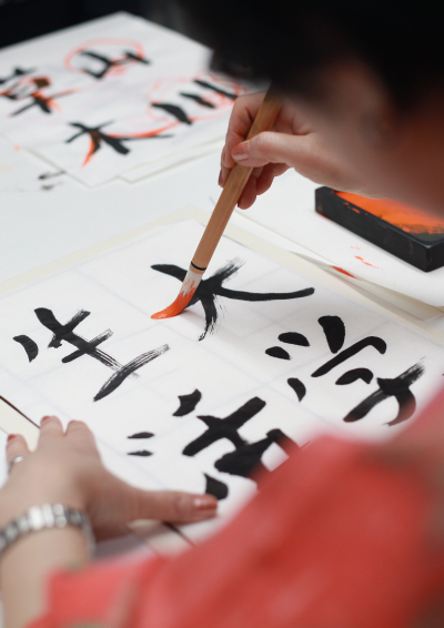 En person tegner japanske skrifttegn