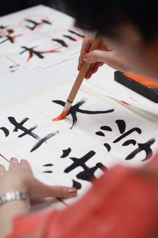 En person tegner japanske skrifttegn